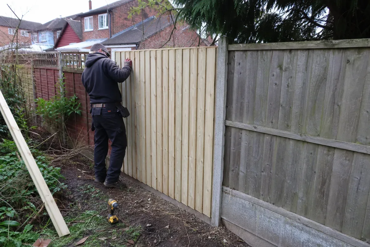 Damaged garden fence being repaired in Sutton Coldfield